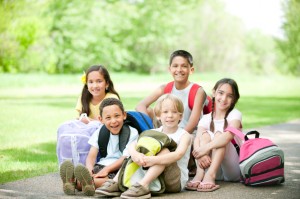 A diverse group of children doing homework together outside.