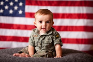 military baby sitting in front of american flag