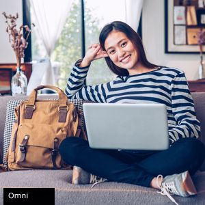 Woman sitting on her couch using her laptop computer.