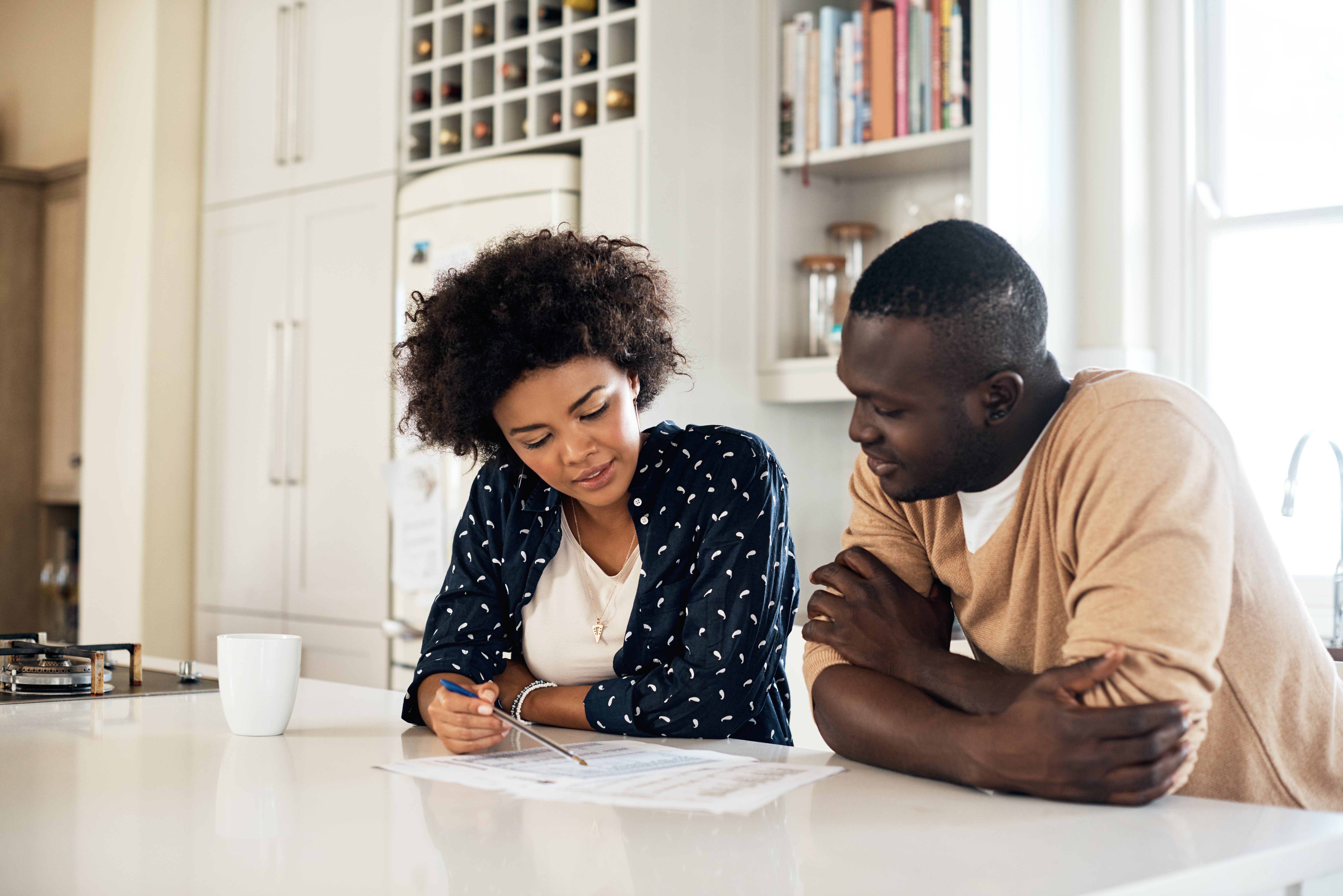A couple doing paperwork in their kitchen.